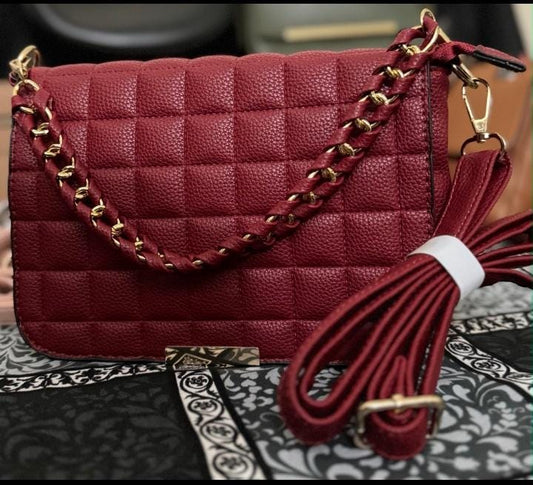 Lace & Luxe quilted leather crossbody bag with gold chain handle, stylish handbag with a sleek design and textured surface.