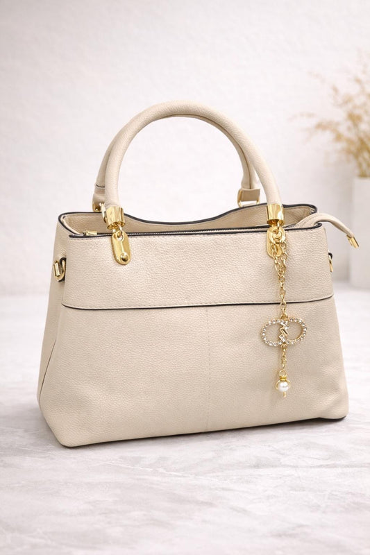 Lace & Luxe faux leather top handle bag with gold charm, crossbody strap, and elegant design for women.